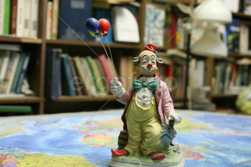 Клоун, карта мира, книги.