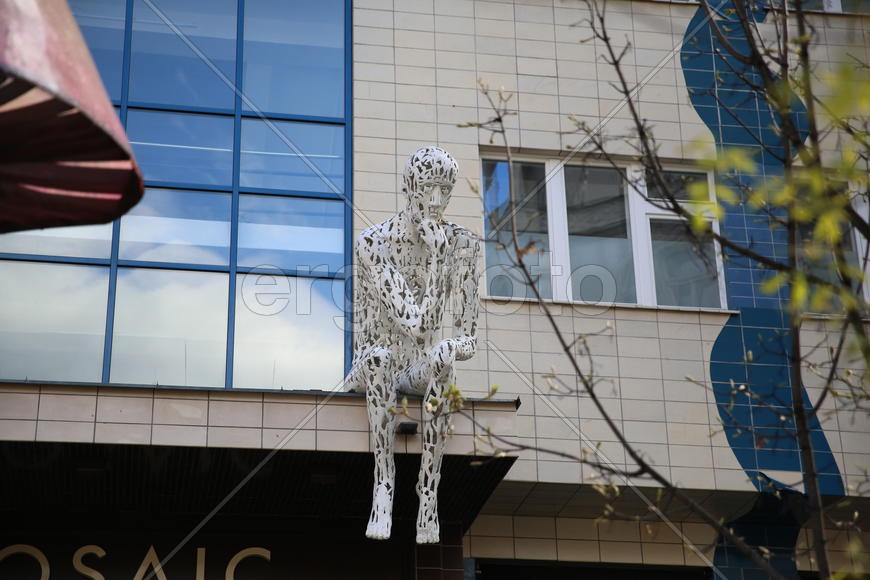 Скульптура сидящего человека