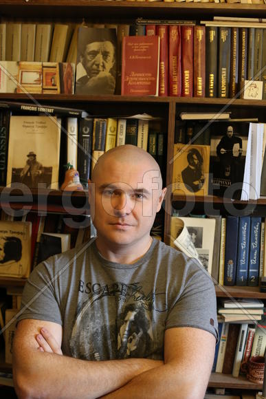 На фоне книг.