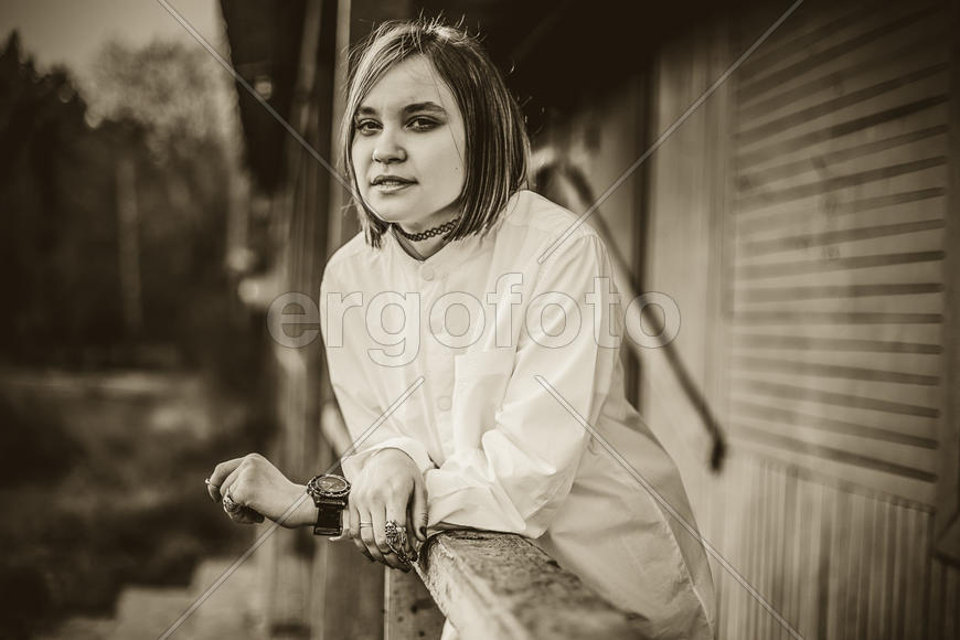 Девушка стоит на крыльце, скрестив руки