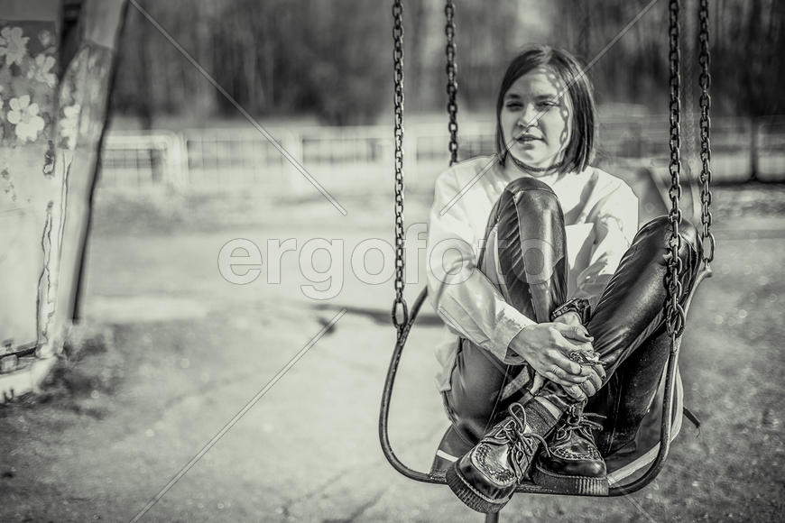 Девушка в рубашке на качелях