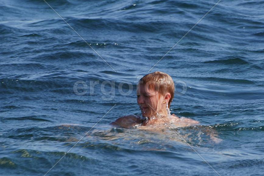 Женщина купается в море