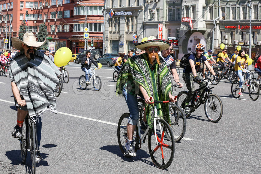 велопробег в Москве. Мужчины в пончо и сомбреро на велосипедах. 
