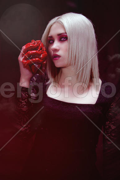 Девушка держит окровавленное сердце, вампир