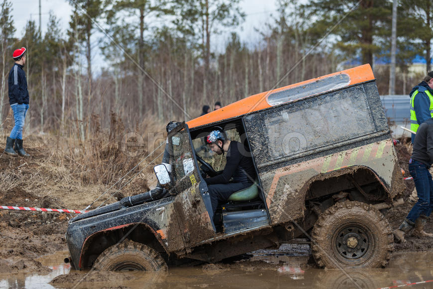 Человек за рулем внедорожника на соревнованиях "Уральская грязь 2015"