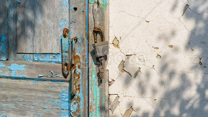Ржавый навесной замок на обветшалой стене