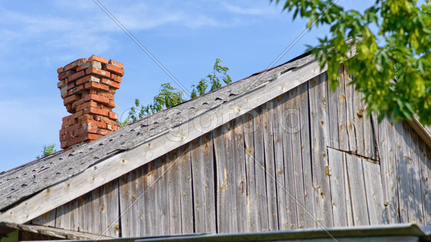 Полуразрушенная труба на старом доме