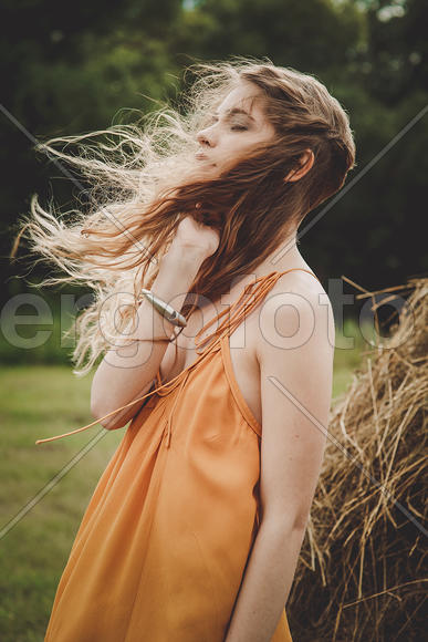 Девушка со светлыми волосами в оранжевом платье
