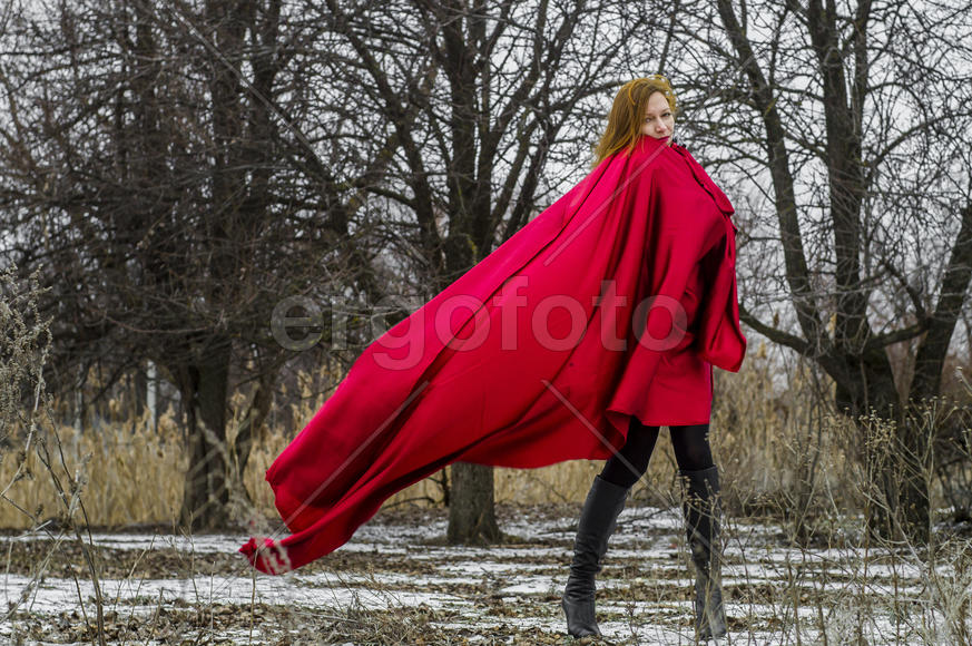 Девушка в развевающемся красном плаще, на фоне леса