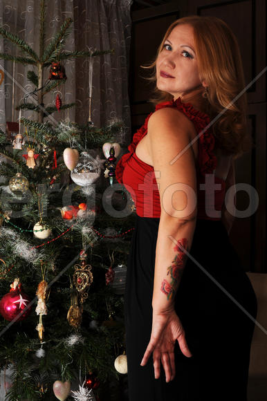 Женщина с татуировкой у новогодней ёлки