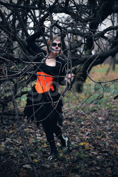 Девушка в маскарадном костюме у дерева