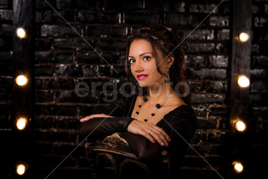 Девушка на фоне чёрной кирпичной стены