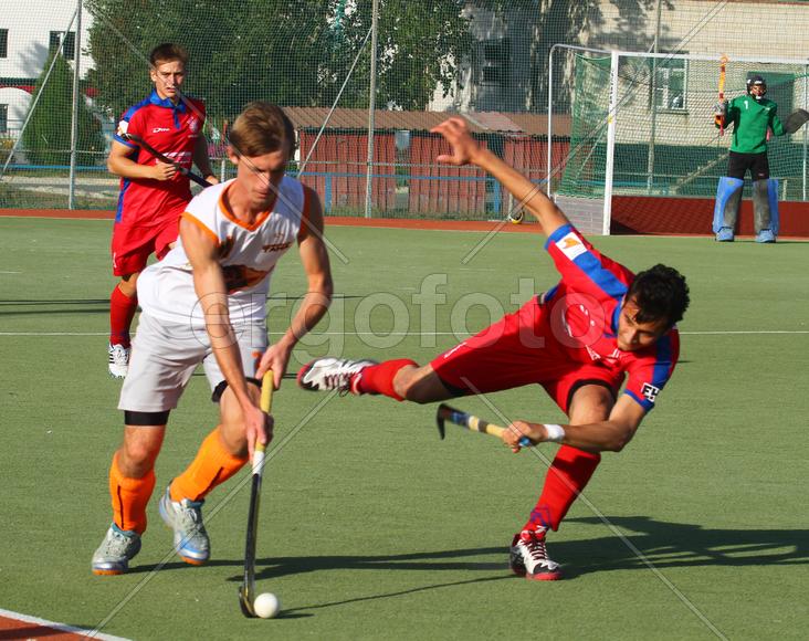 Двое мужчин играют в хоккей на траве