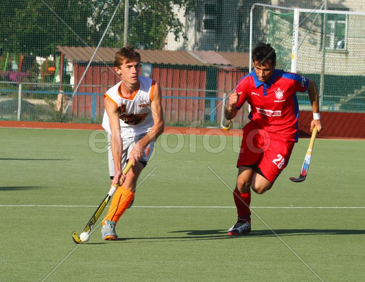 Двое мужчин играют в хоккей на траве