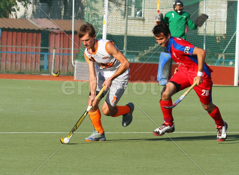 Двое мужчин играют в хоккей на траве