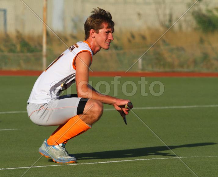 Мужчина играет в хоккей на траве