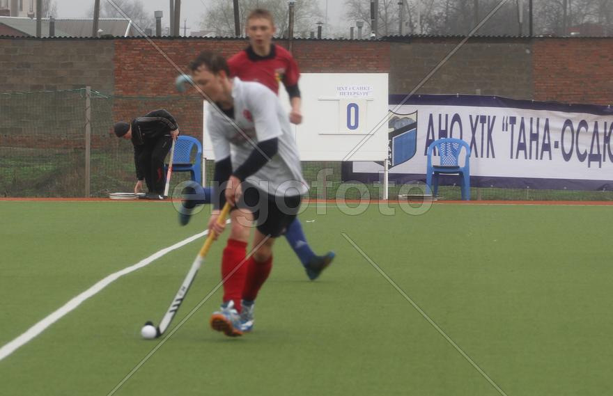 Двое мужчин играют в хоккей на траве