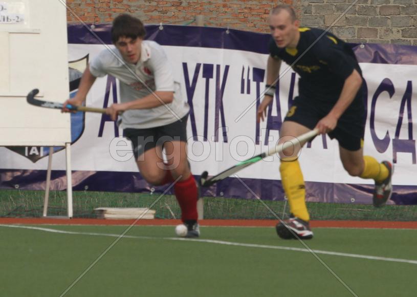 Двое мужчин играют в хоккей на траве