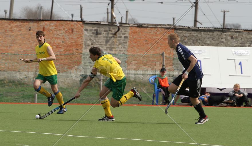 Трое мужчин играют в хоккей с мячом