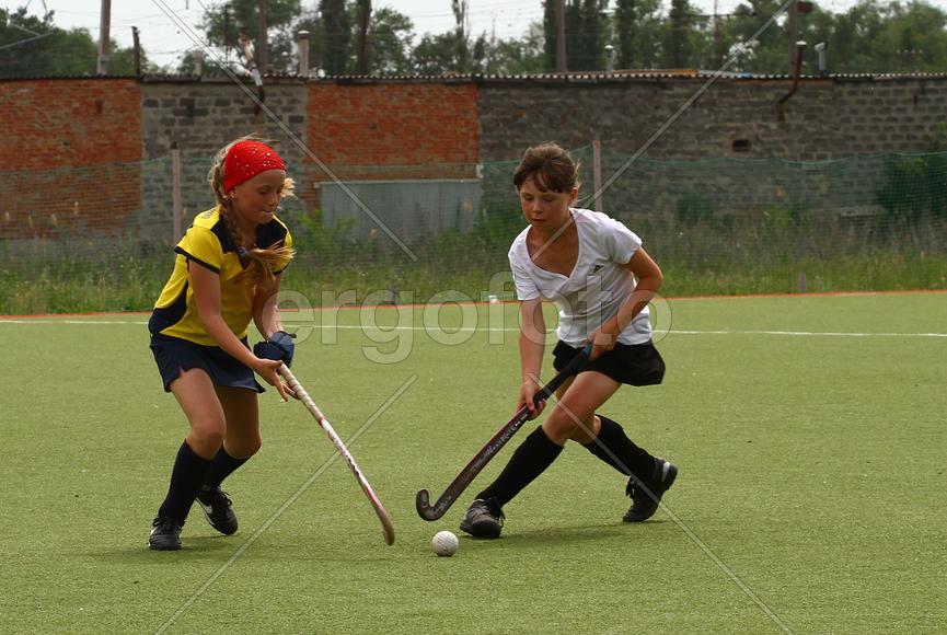 Девочки играют в хоккей на траве