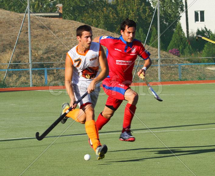 Двое мужчин играют в хоккей на траве