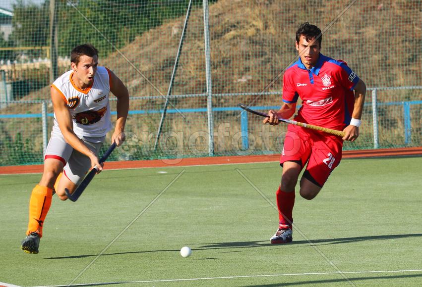 Двое мужчин играют в хоккей на траве