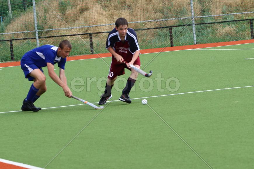 Двое мужчин играют в хоккей на траве