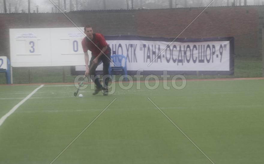 Мужчина с клюшкой играет в хоккей с мячом