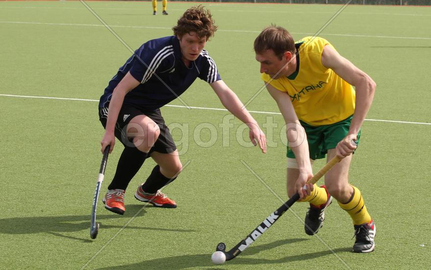 Двое мужчин играют в хоккей на траве