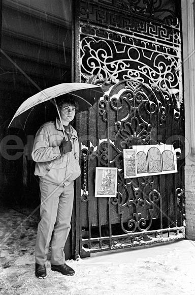 СССР. Ленинград. Художник. Молодой художник продает свои картины в одной из подворотен на улице