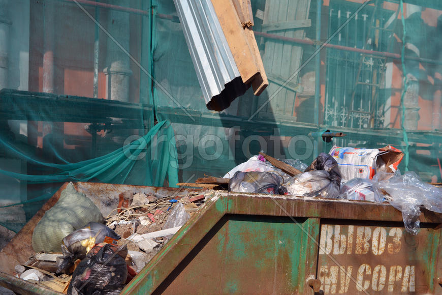 Контейнер для мусора на строительной площадке. На контейнере сделана надпись - вывоз мусора