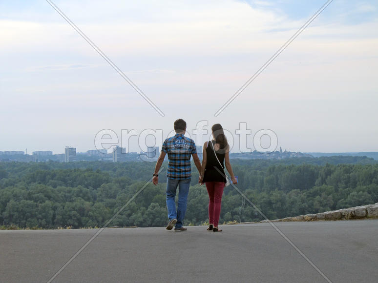 Пара, держащаяся за руки, на фоне города