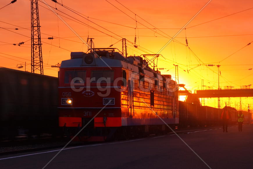 Поезд уезжает на закате со станции 