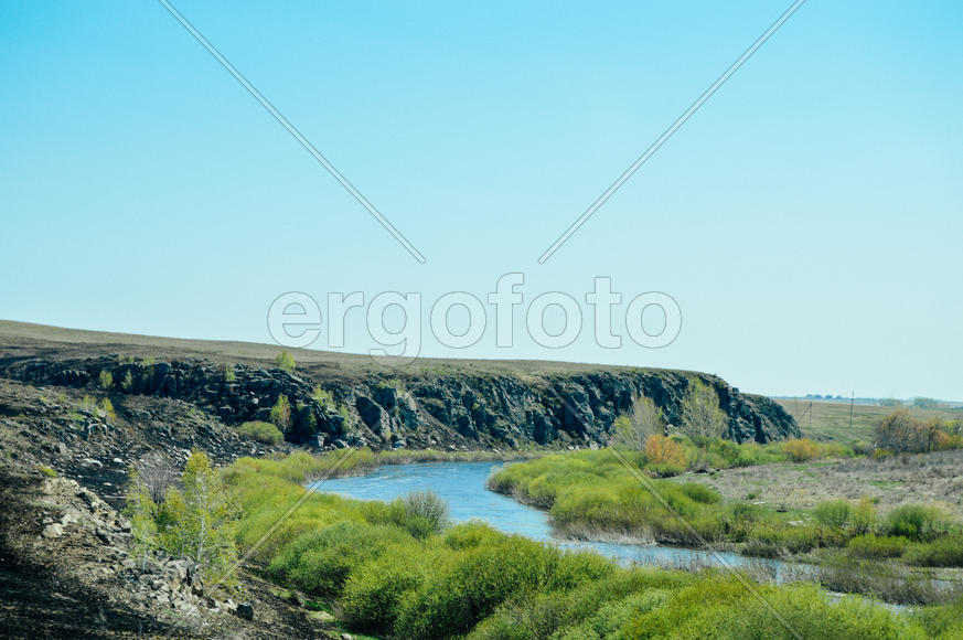 Река в овраге на фоне голубого неба 