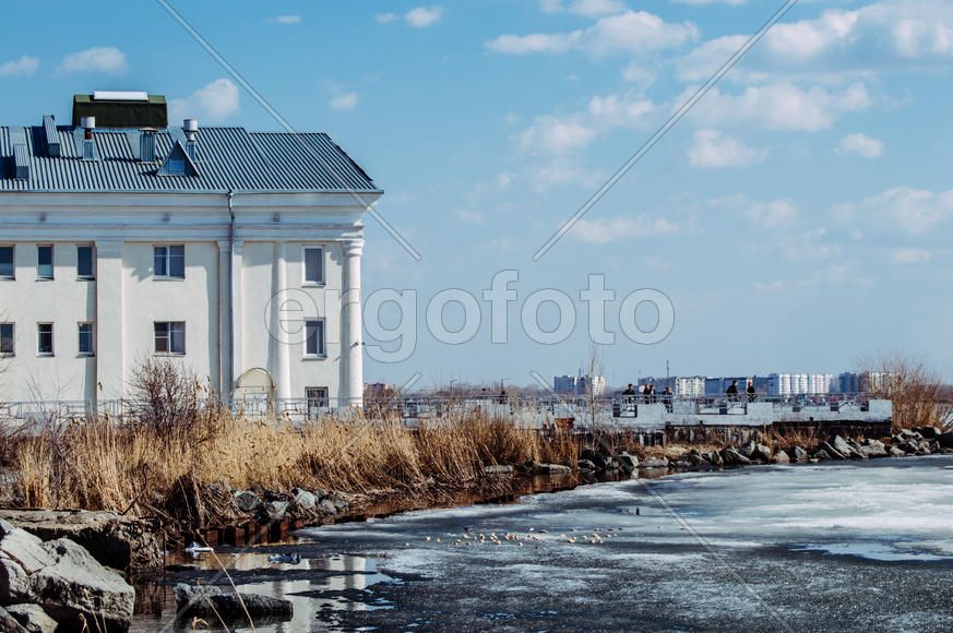 Белое здание на берегу замершего озера 