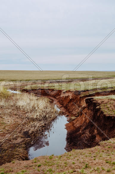 Река в овраге на фоне голубого неба 
