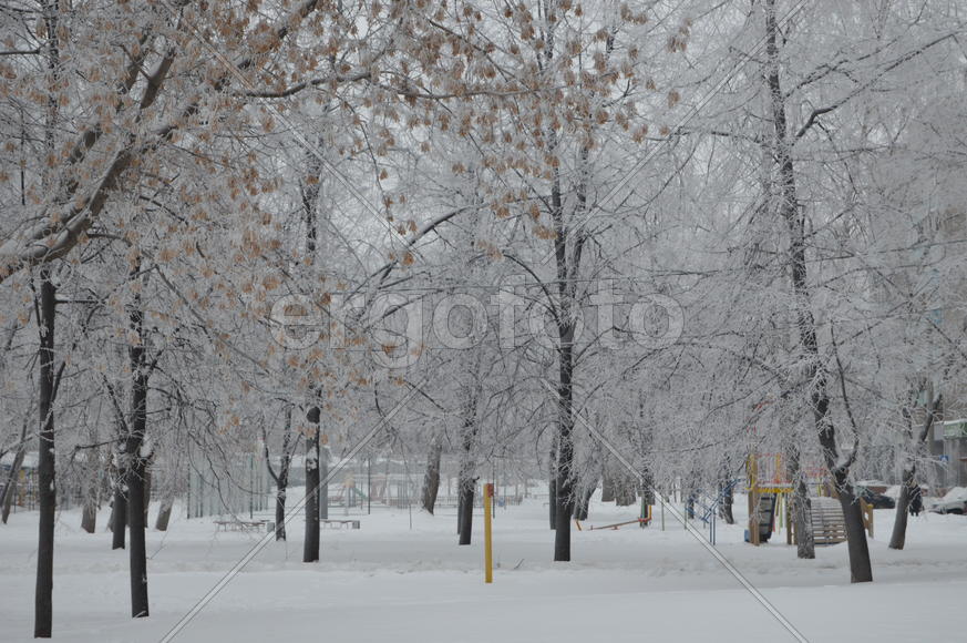 Детская игровая площадка занесенная снегом холодной зимой 