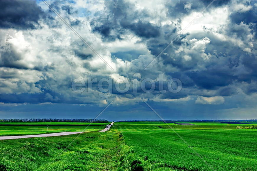 Зелены поля под ярко синими облаками 