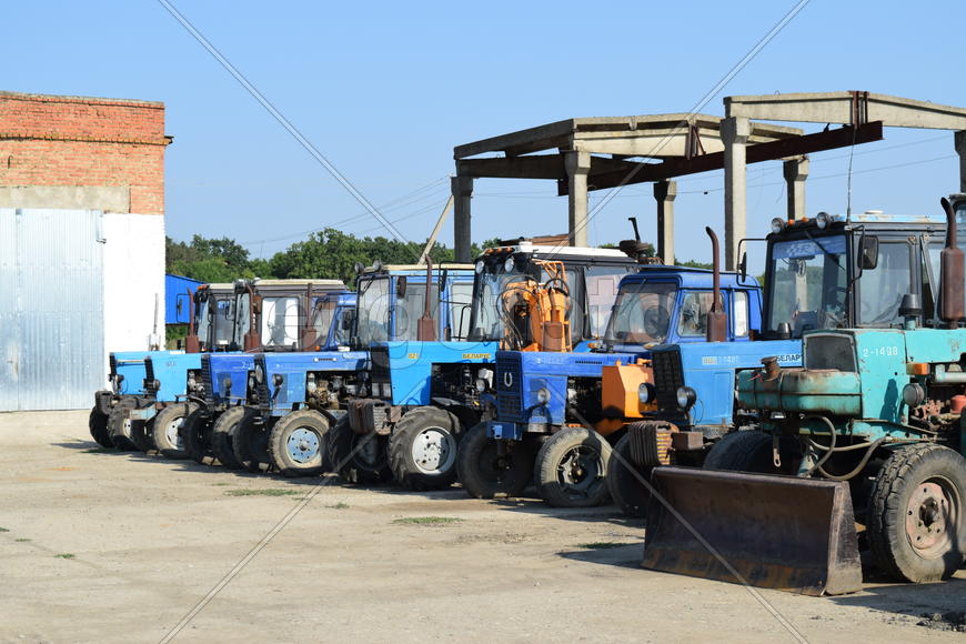 Tractor, standing in a row. Agricultural machinery. Parking of agricultural machinery.