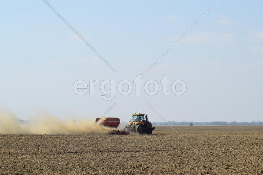 Russia, Temryuk - 19 July 2015: Tractor rides on the field and makes the fertilizer into the soil. C