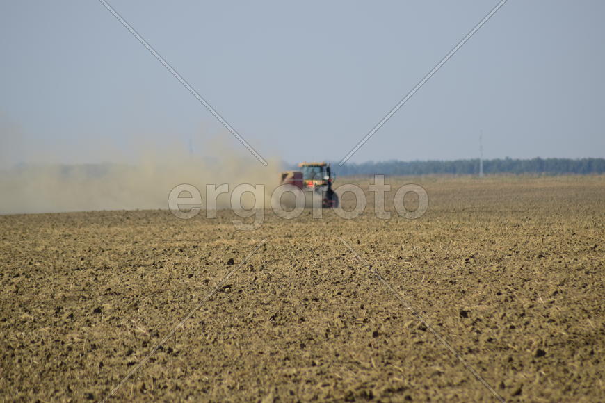 Russia, Temryuk - 19 July 2015: Tractor rides on the field and makes the fertilizer into the soil. C