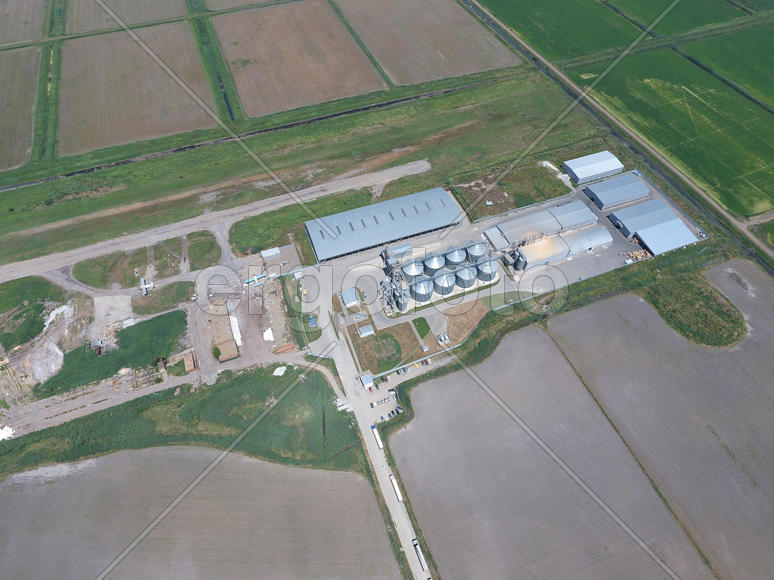 Plant for the drying and storage of grain. Rice plant in the middle of fields. Top view.