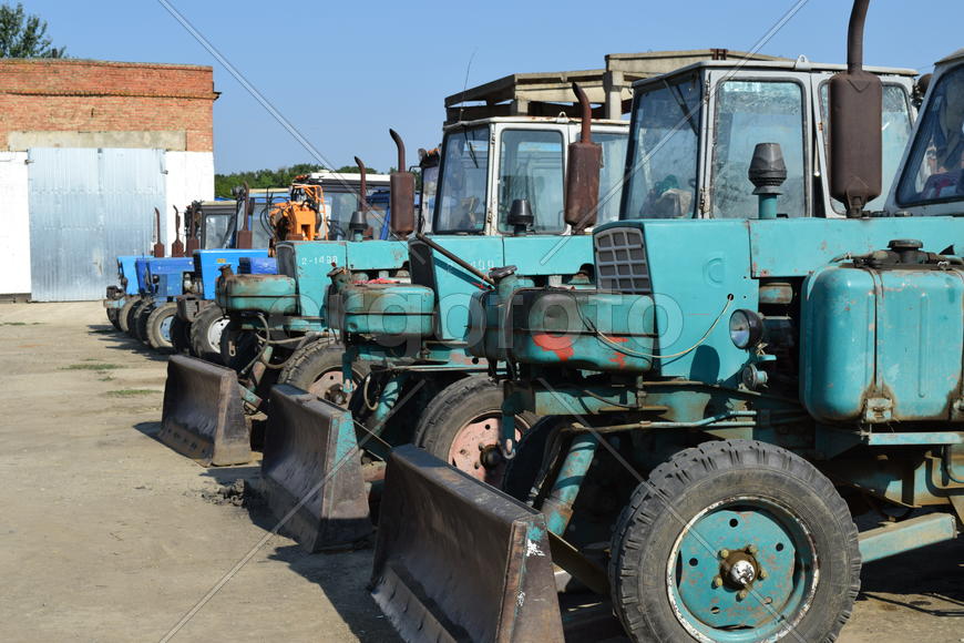 Tractor, standing in a row. Agricultural machinery. Parking of agricultural machinery.