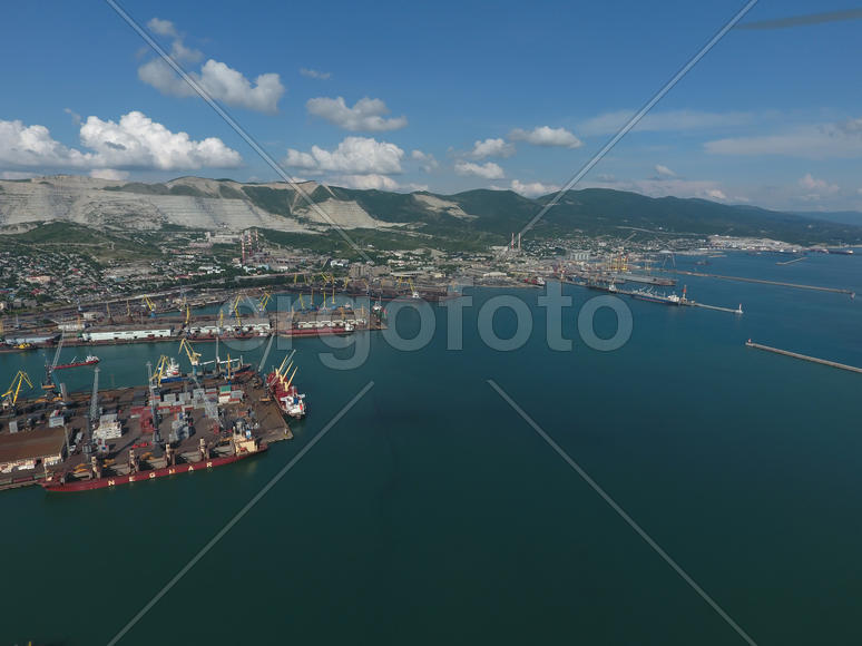 Industrial seaport, top view. Port cranes and cargo ships and barges. Loading and shipment of cargo 