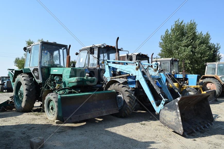 Tractor, standing in a row. Agricultural machinery. Parking of agricultural machinery.