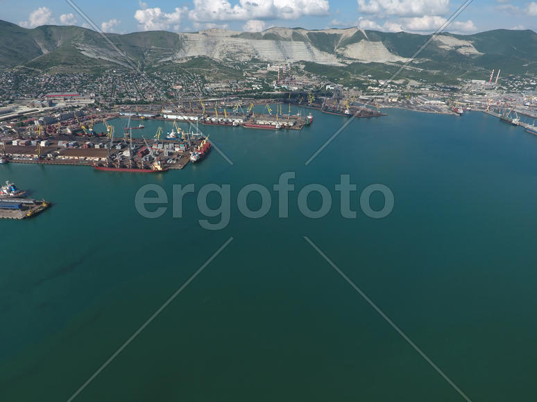 Industrial seaport, top view. Port cranes and cargo ships and barges. Loading and shipment of cargo 