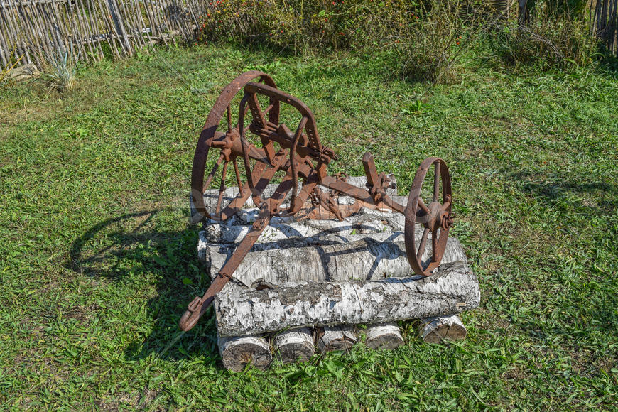 Старый железный плуг для копки огорода.