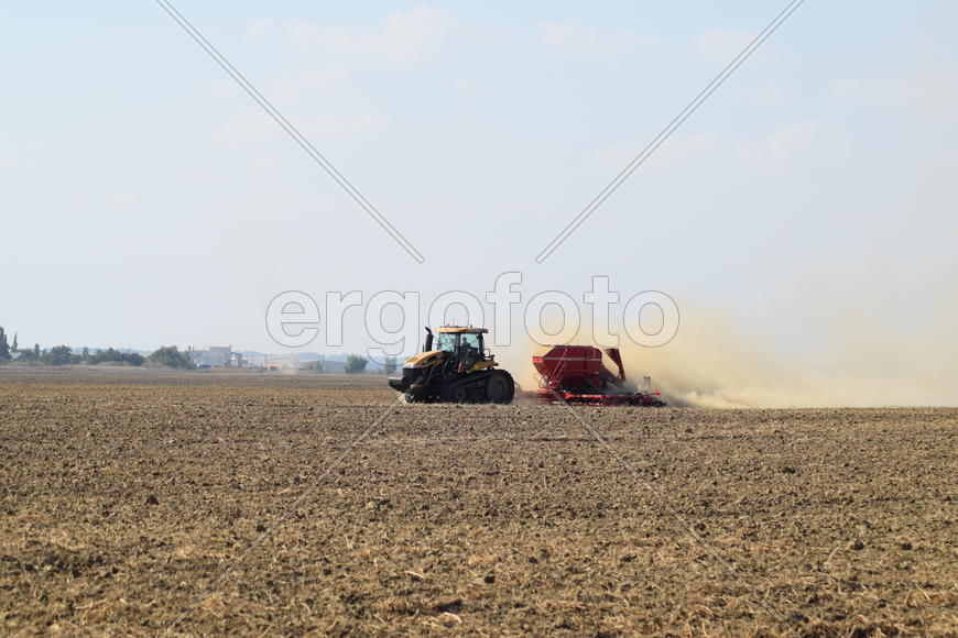 Russia, Temryuk - 19 July 2015: Tractor rides on the field and makes the fertilizer into the soil. C