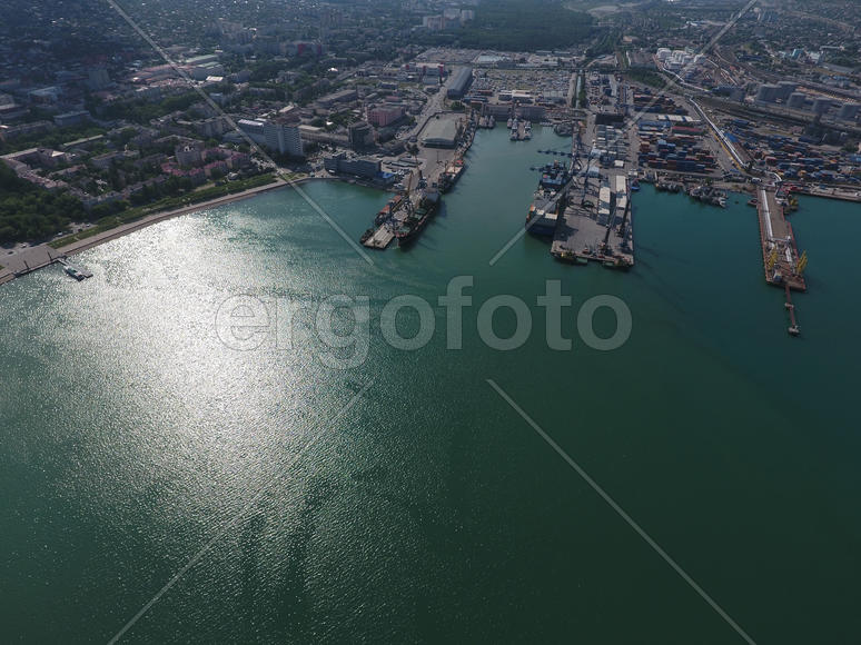 Industrial seaport, top view. Port cranes and cargo ships and barges. Loading and shipment of cargo 