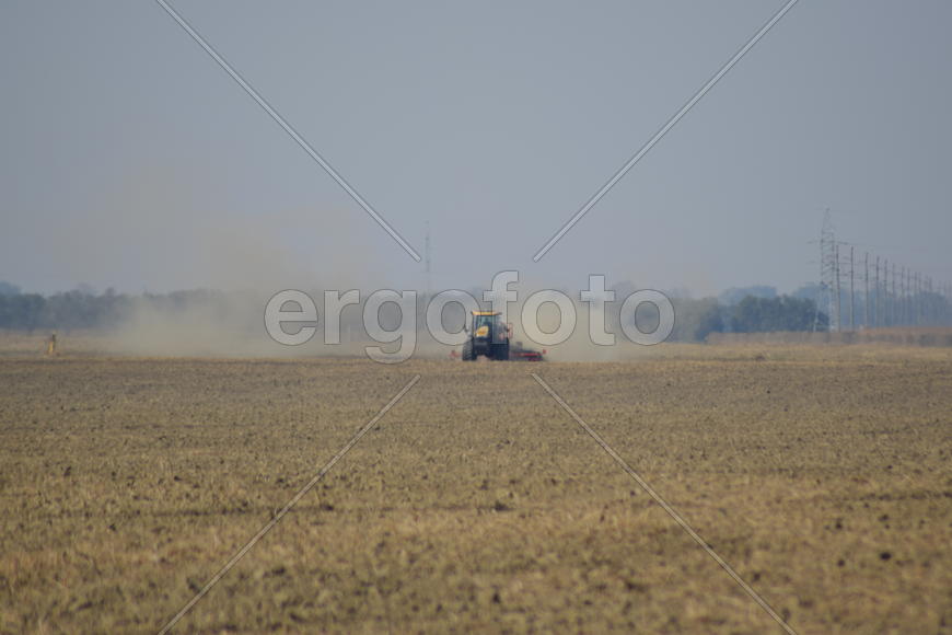 Russia, Temryuk - 19 July 2015: Tractor rides on the field and makes the fertilizer into the soil. C